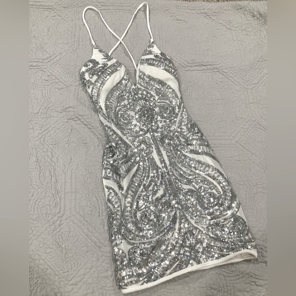 small white dress with silver sequence design, low V neck, cross over tie back.